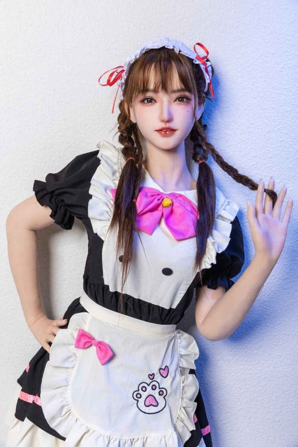 Realistic love doll dressed as a cute maid in cosplay costume, holding a playful pose.