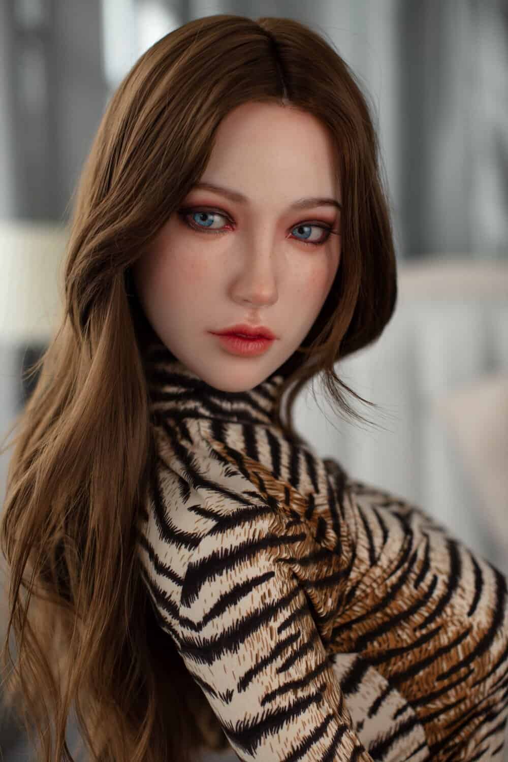 Realistic female doll with striking blue eyes and auburn hair, wearing a stylish animal print top. Perfect for lifelike companionship and intimate moments.
