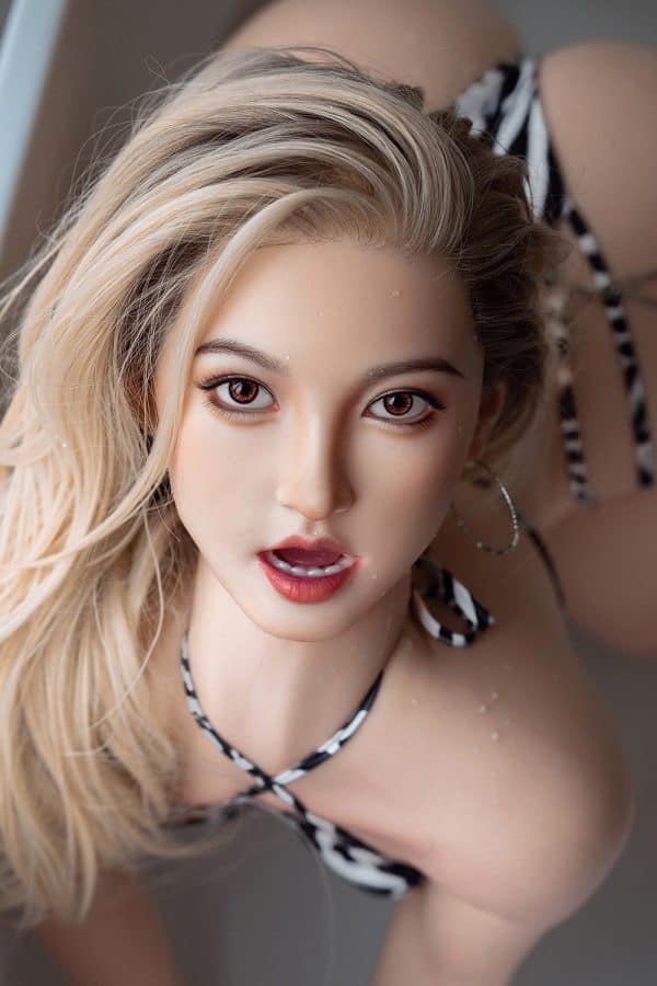 Blonde woman with piercing eyes and striped bikini top, portrait of seducedoll silicone companion.