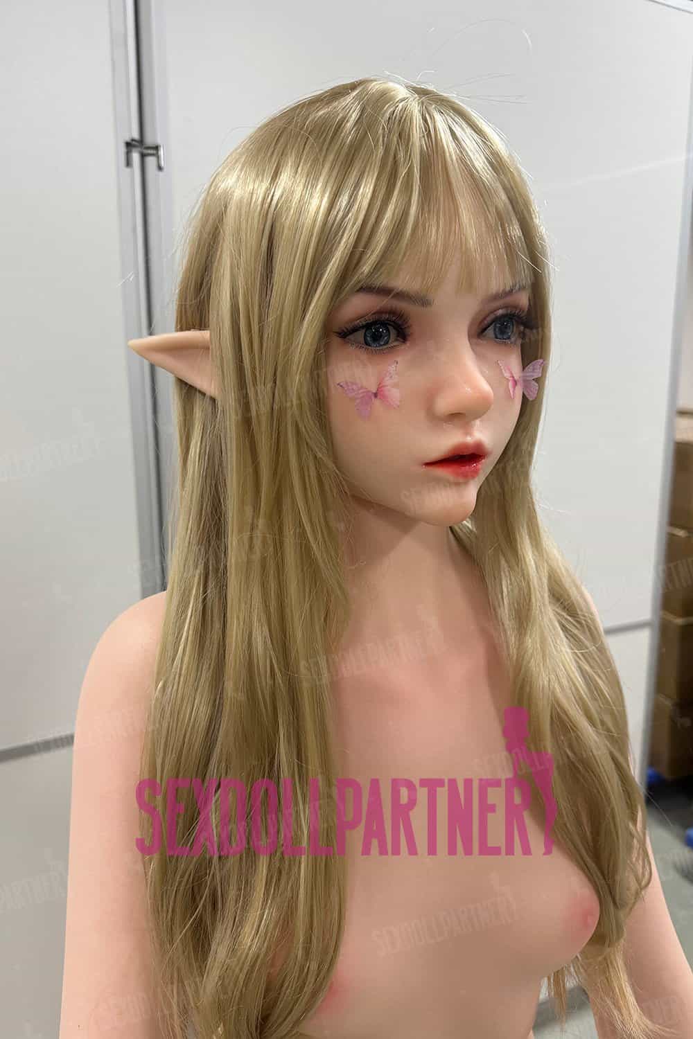 Soft blonde doll with elf ears and butterfly face paint, realistic artificial female mannequin for adult love dolls.