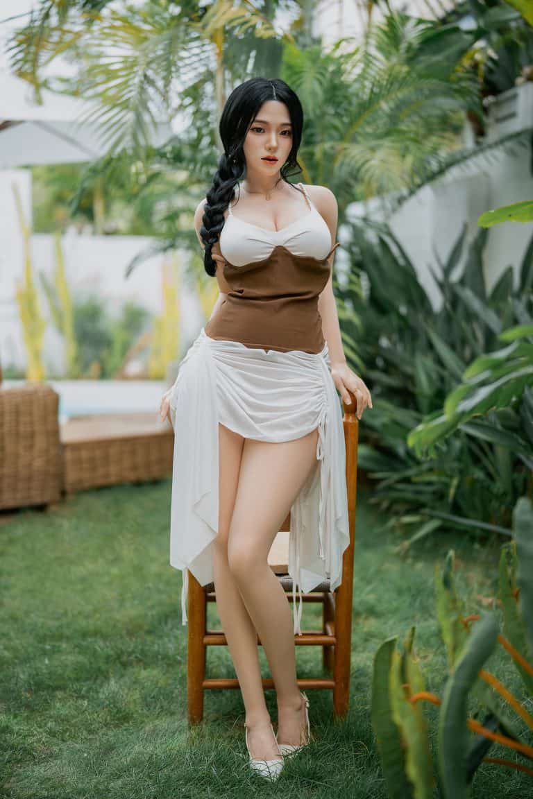 Silicone doll in garden, realistic erotic art, seducedoll.com promotional image, outdoor swimsuit woman with dark hair and tan skin, ideal for adult product SEO.
