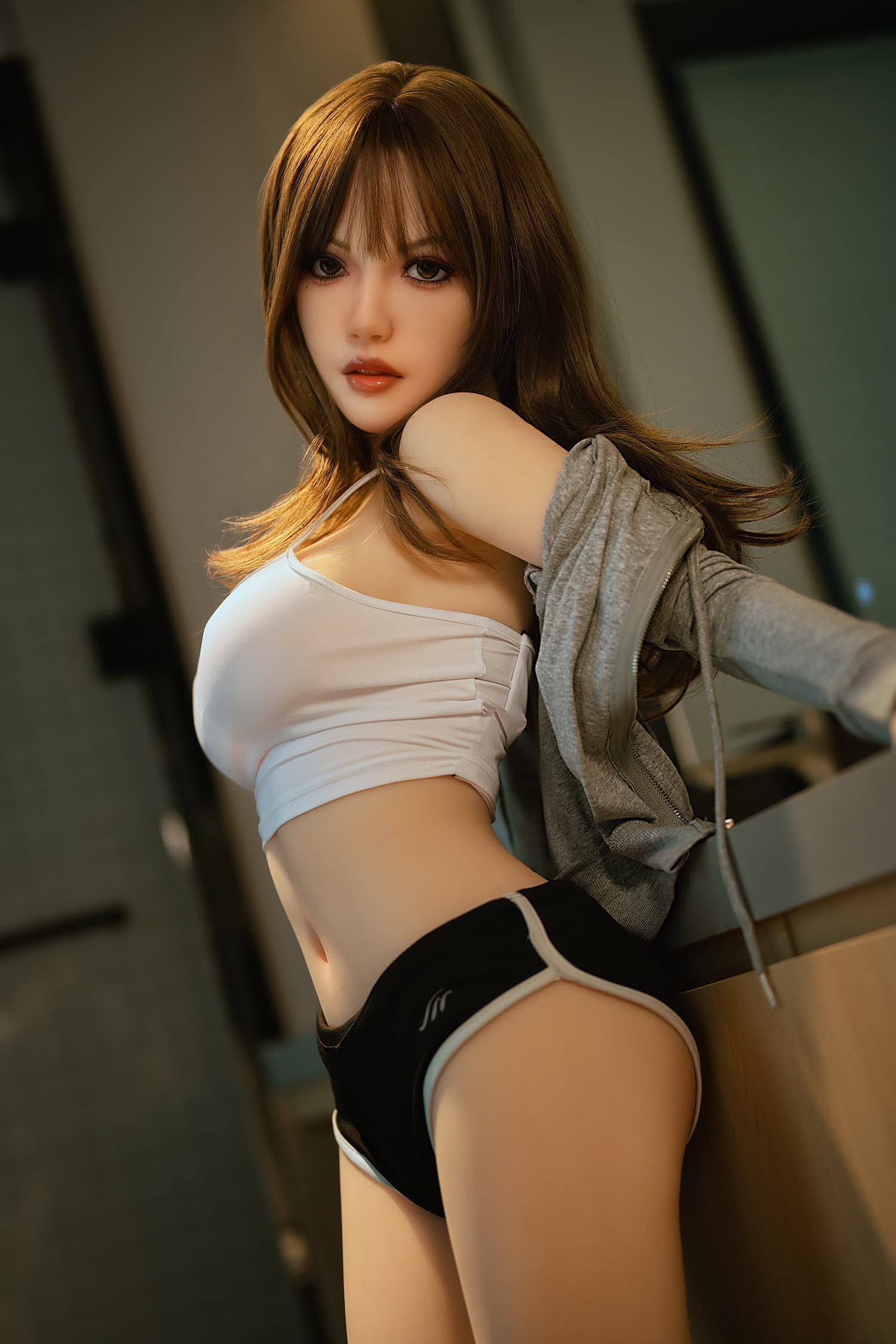Silicone female doll with brown hair in sporty attire, indoor setting for intimate lifestyle photography.