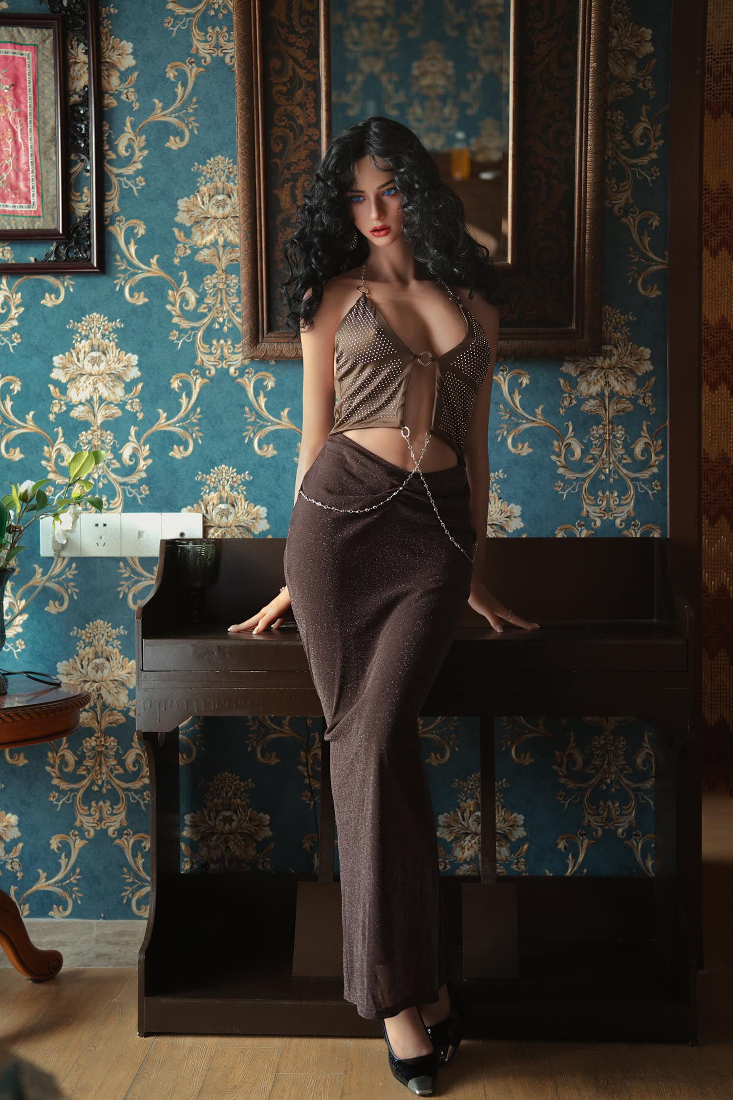 Seductive female doll in stylish evening outfit with dark hair posing indoors.