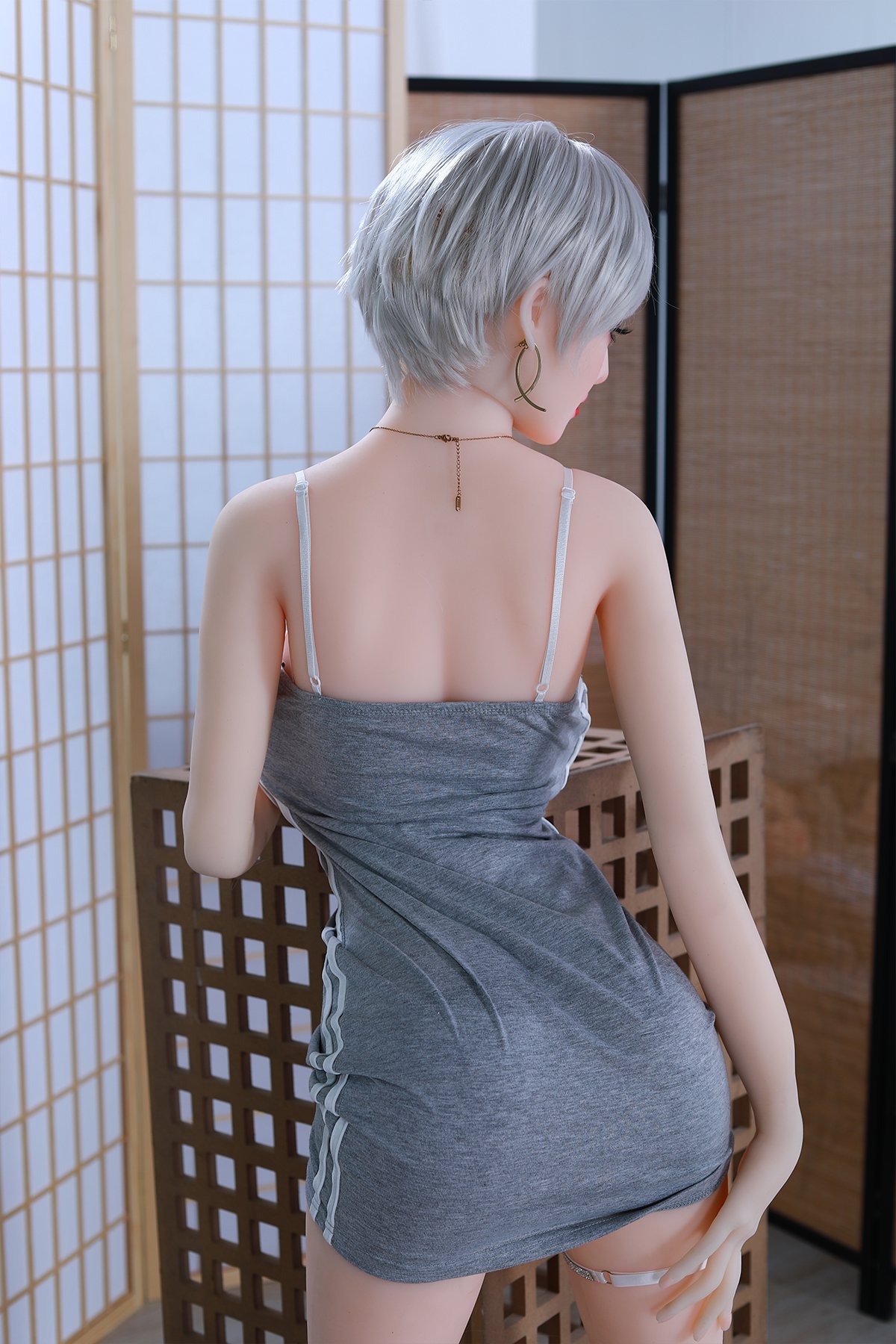 Elegant doll with short silver hair wearing a gray dress, stylish jewelry, and pose looking away.