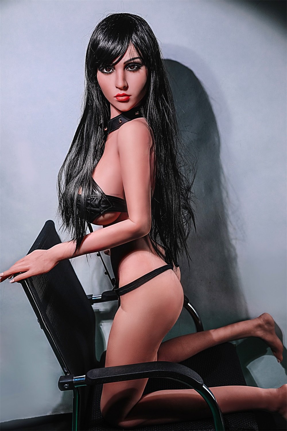 Realistic sex doll female figure in black lingerie on office chair, seductive pose, synthetic doll model for adult pleasure, SeduceDoll.