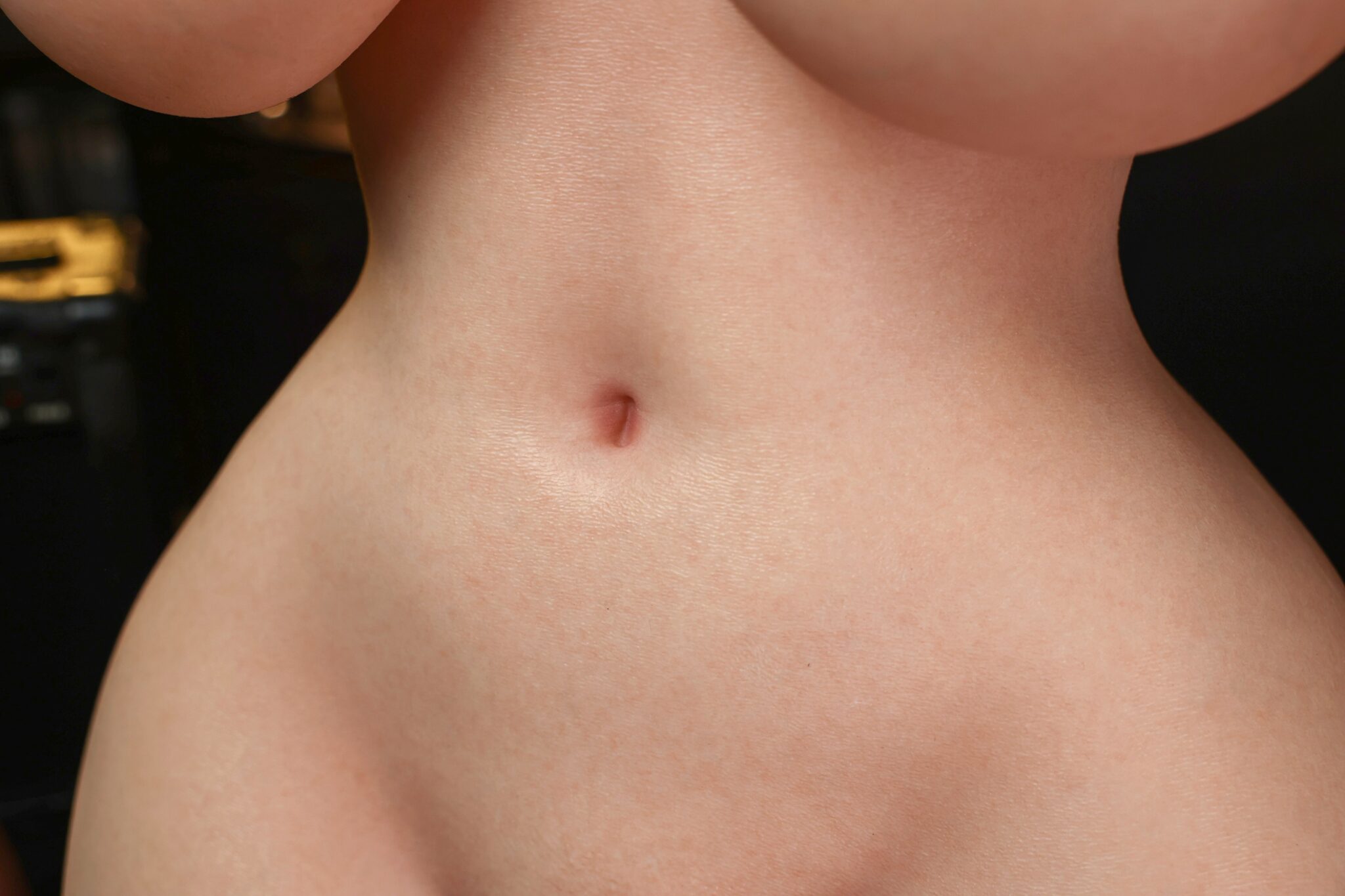 Realistic female cyber doll torso with detailed skin texture showcasing a natural abdomen.