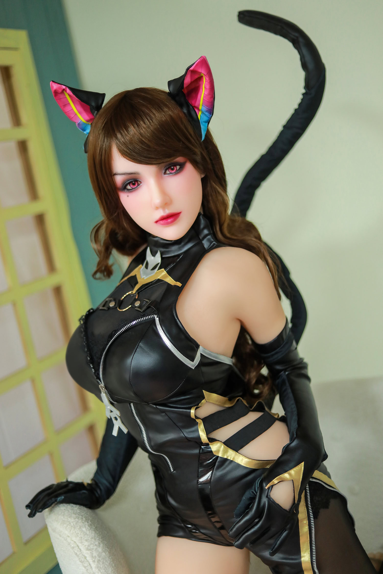 Sexy anime-style doll dressed as a cat girl in a black leather costume with gold accents, celebrating cosplay and fantasy.