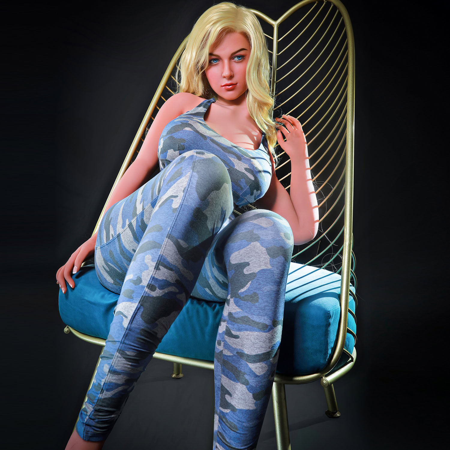 Realistic sex doll with blue eyes and blonde hair in a camouflage outfit on a stylish chair.