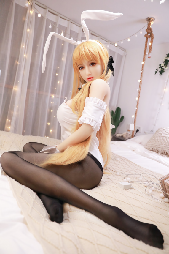 Cute doll dressed as bunny in playful costume sitting on bed, seductive and realistic appearance.