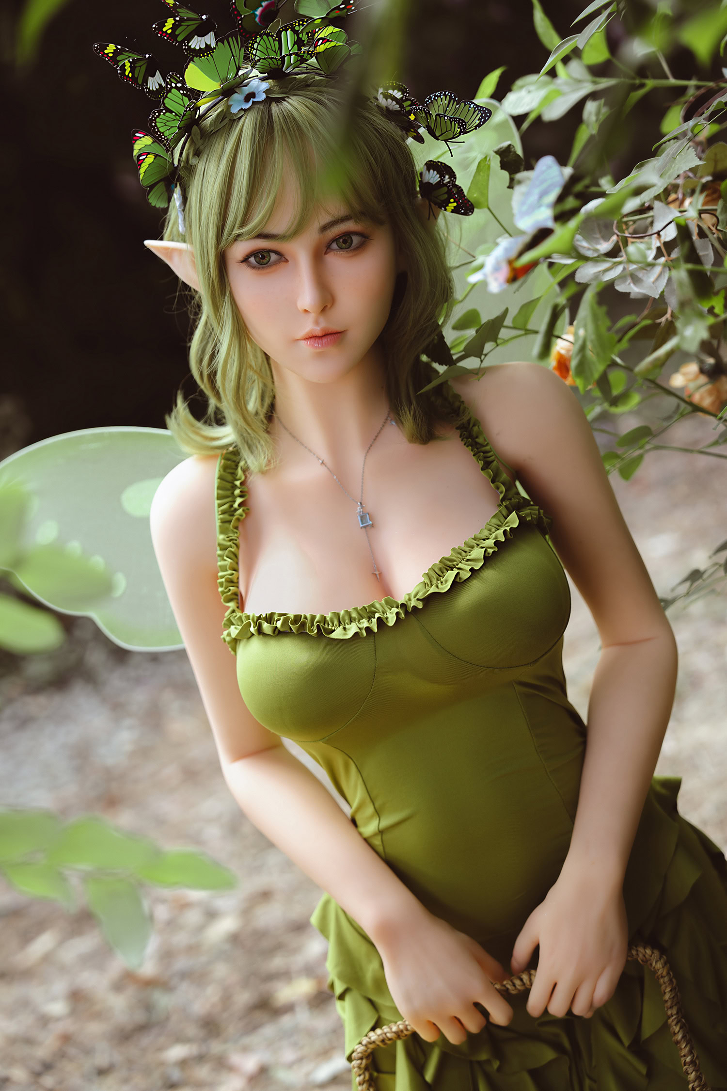 Beautiful elf doll with green hair and butterfly wings in fantasy forest setting.