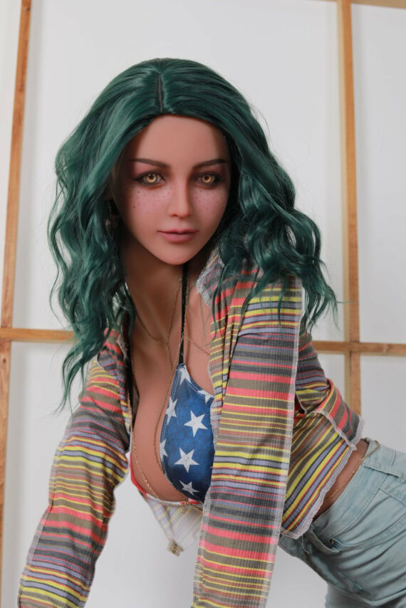 Vibrant green-haired female doll with striped colorful shirt and American flag bikini top, in a modern studio setting.
