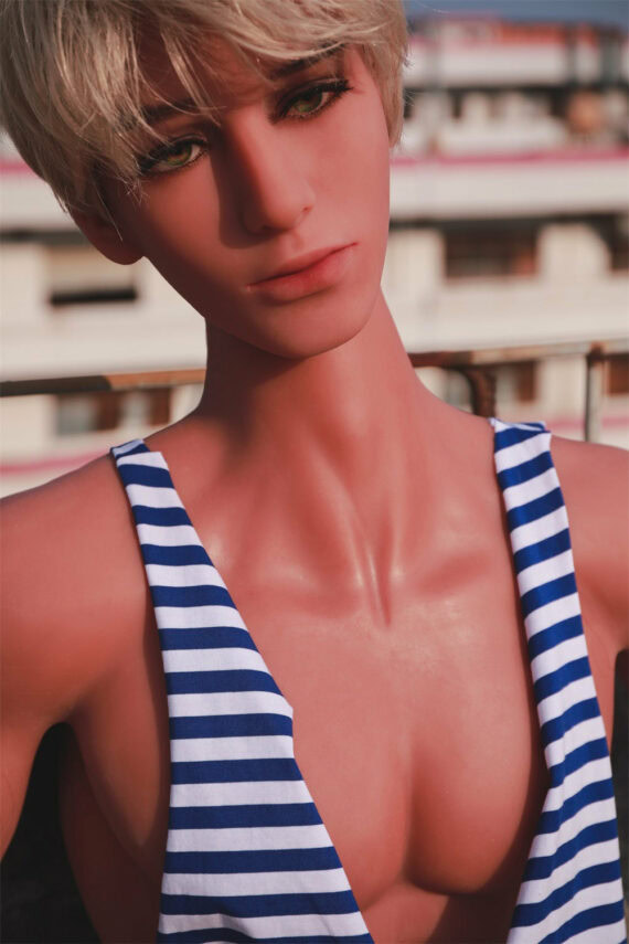 Realistic female doll with short blonde hair wearing a striped tank top outdoors.