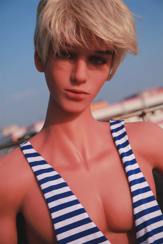Realistic sex doll with short blonde hair and striped swimsuit, outdoor setting, detailed skin texture and lifelike features.