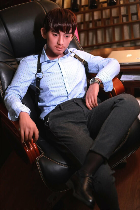 Realistic sex doll male figure sitting in a leather armchair, dressed in business attire, in a modern office setting.