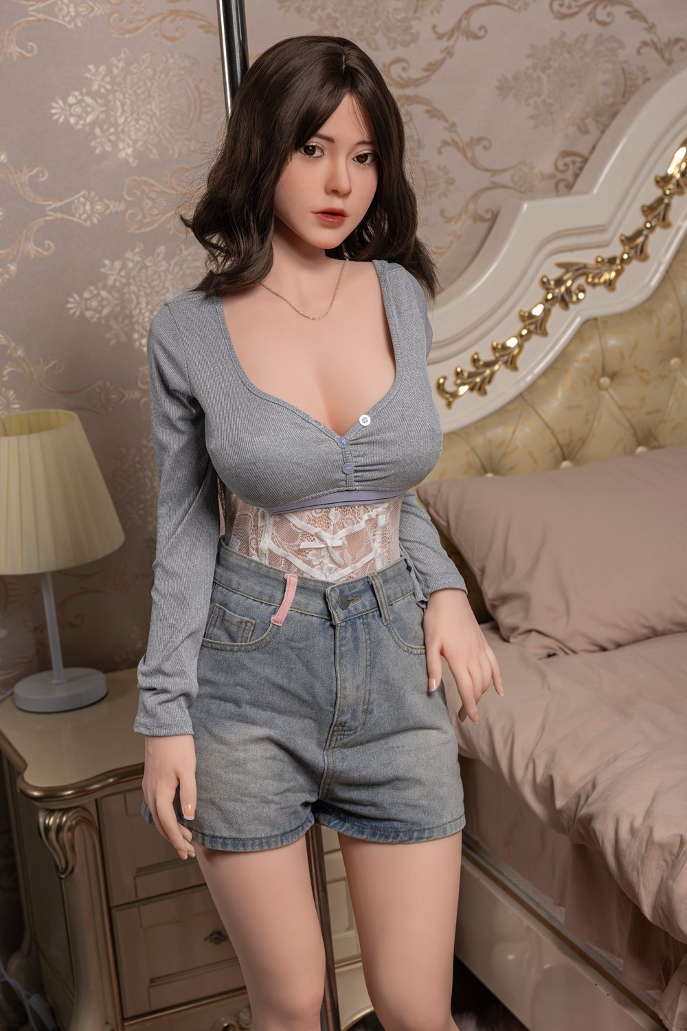 Cute female doll with realistic features in a cozy bedroom setting.
