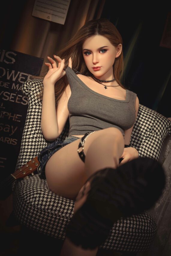 Realistic silicone doll sitting on checkered armchair in a cozy modern setting.