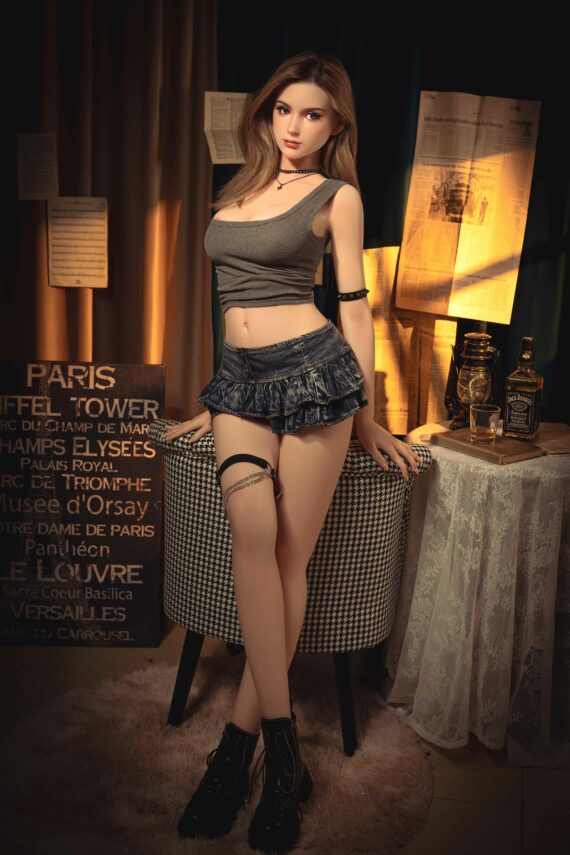 Lifelike female doll posing indoors with Paris-themed decor and stylish outfit for adult companionship.