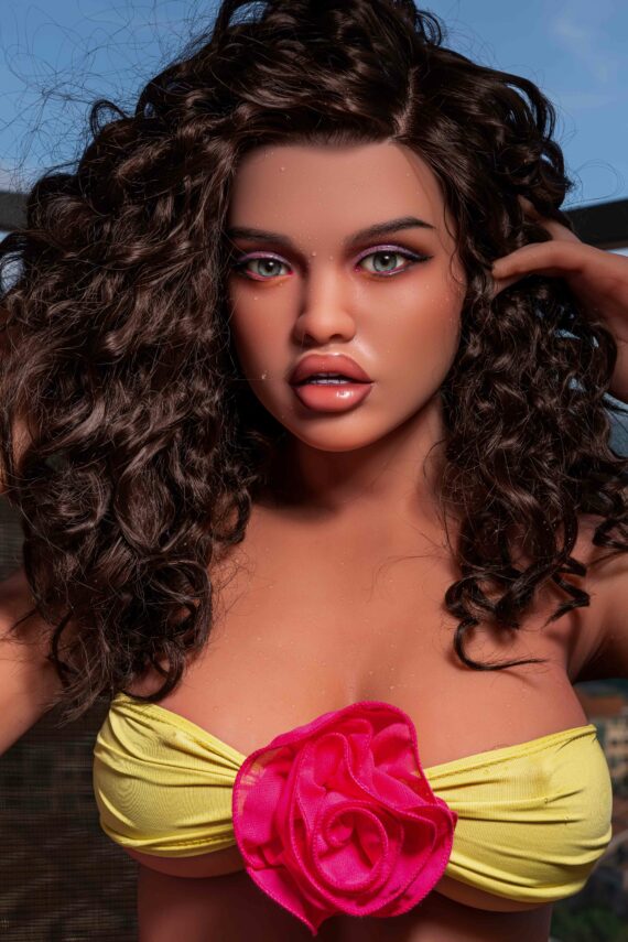 Realistic female doll with curly hair and captivating eyes, dressed in a yellow top with pink floral detail.