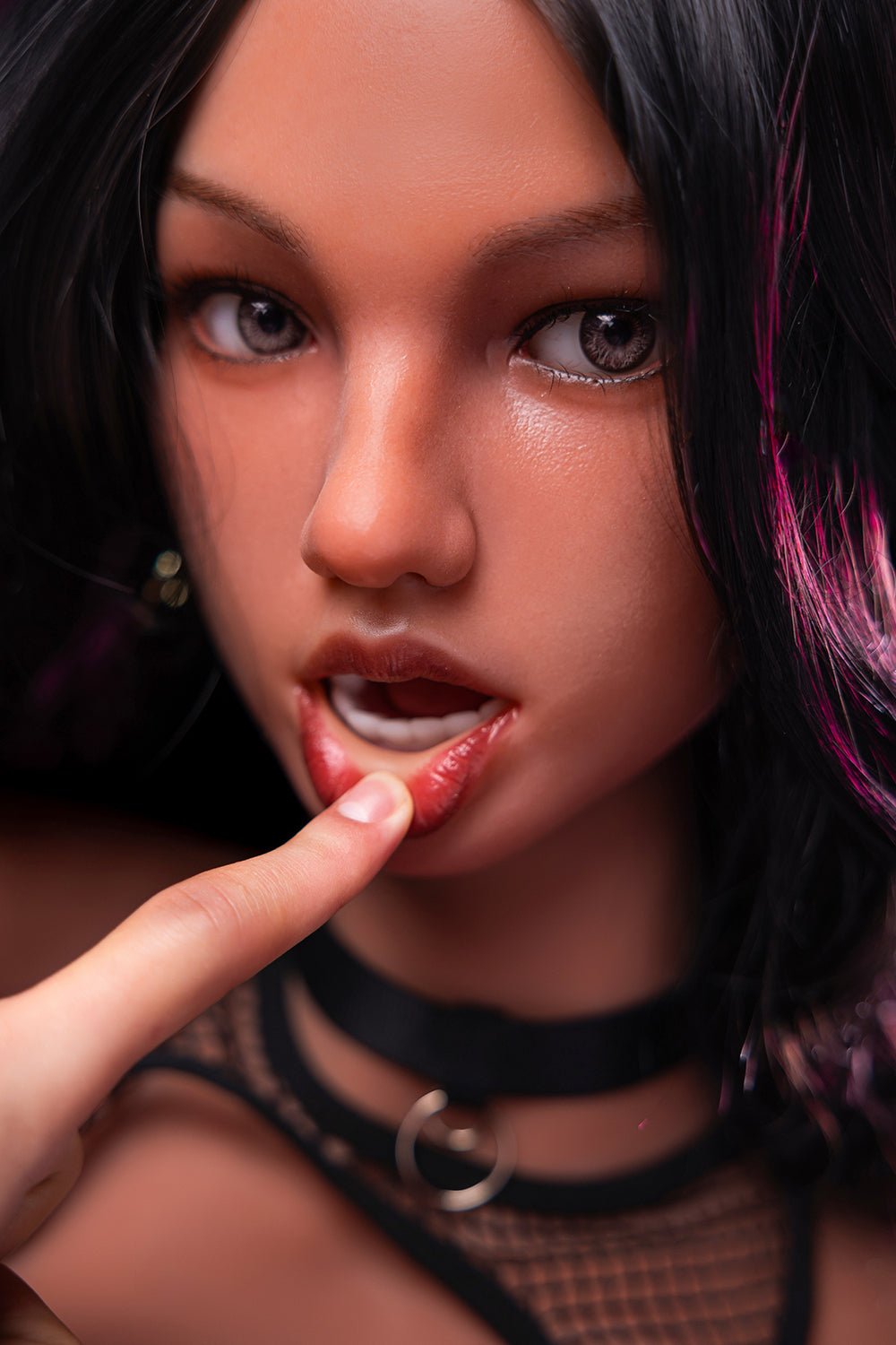 Realistic sex doll close-up face with intense expression and pink highlights in hair.