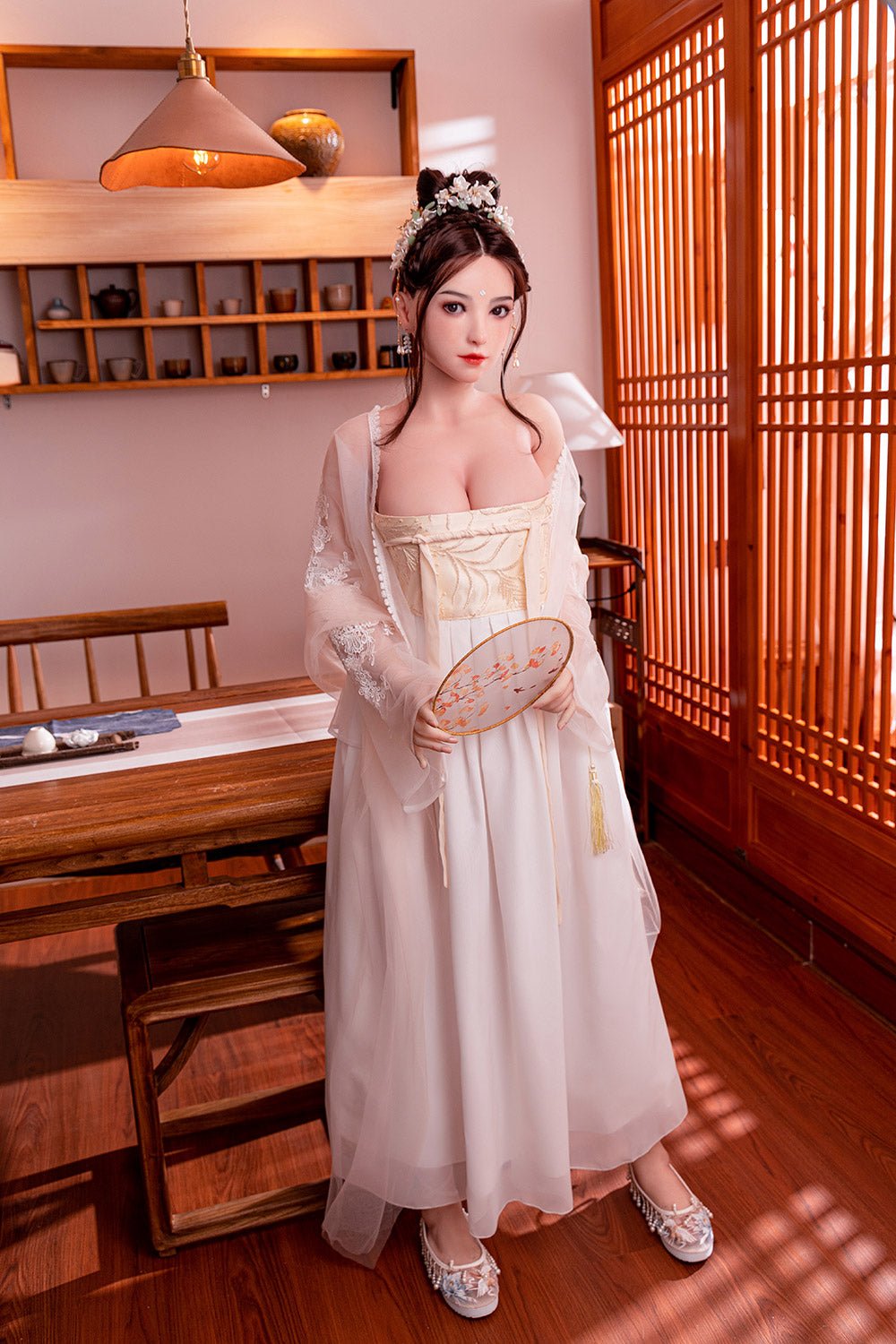 Elegant Asian woman dressed in traditional Hanfu with floral accessories, holding a decorative fan, in a cozy wooden-themed room.