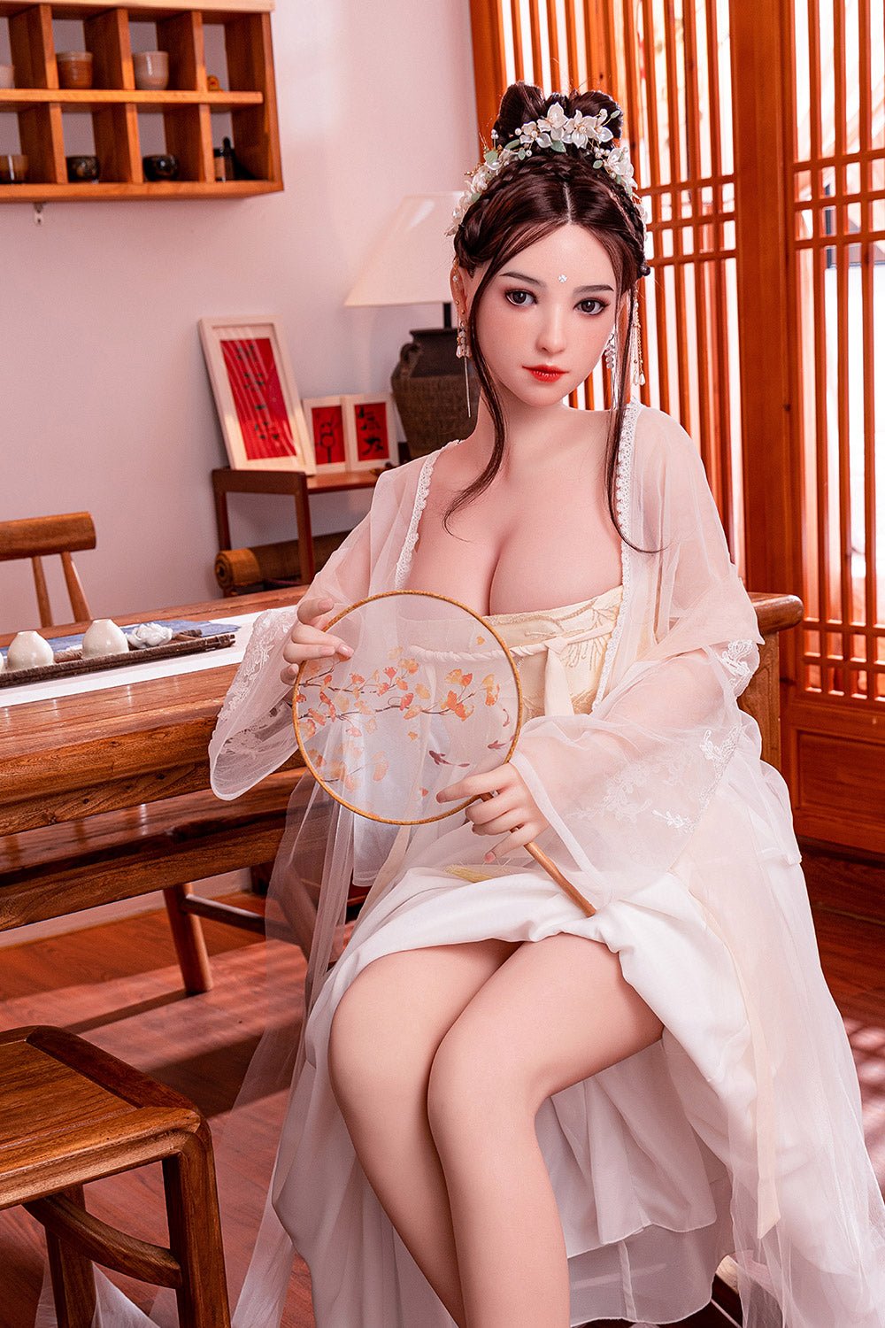Elegant Asian woman in traditional dress with floral hair accessory, holding a silk fan in a cozy, wooden tea room setting.
