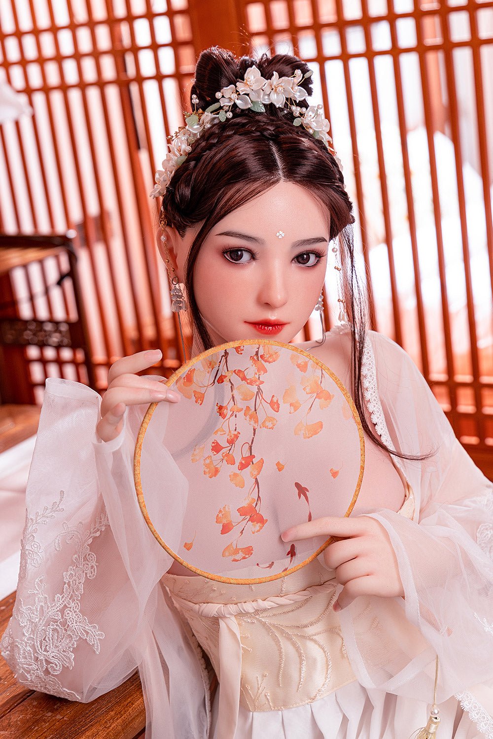Silicone doll in traditional Chinese attire holding a round fan with floral design, elegant hair accessories, and detailed embroidery.