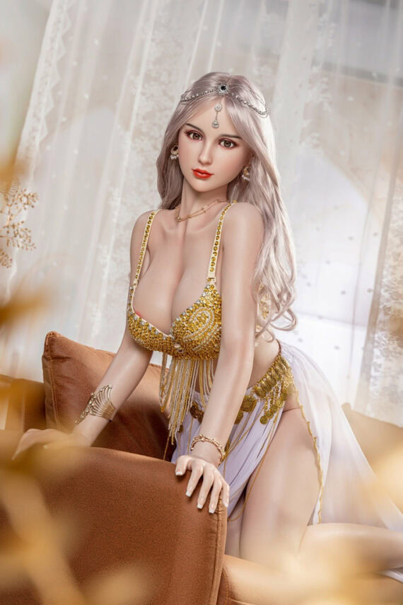 Seductive female doll in glamorous golden outfit sitting on sofa.