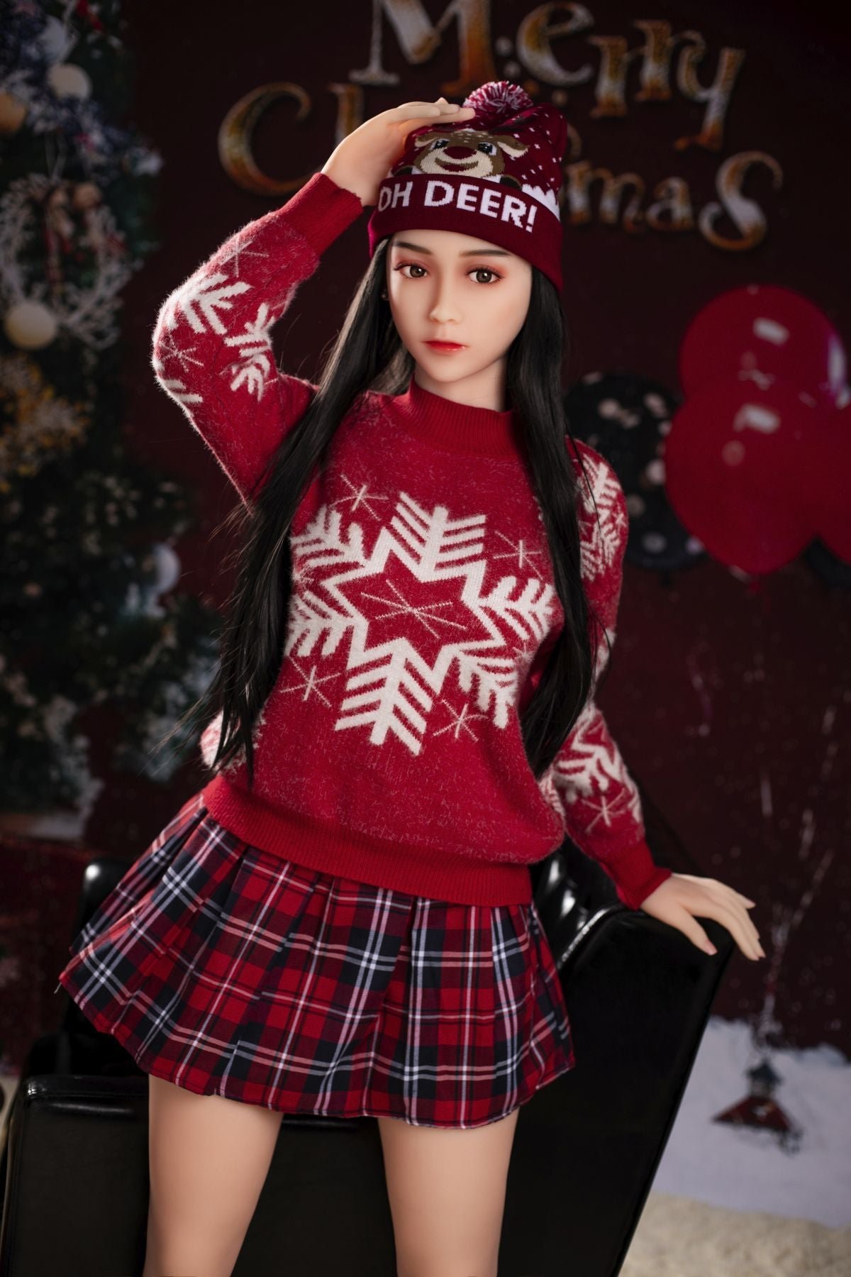 Realistic female Christmas doll in festive outfit with holiday decorations on background.