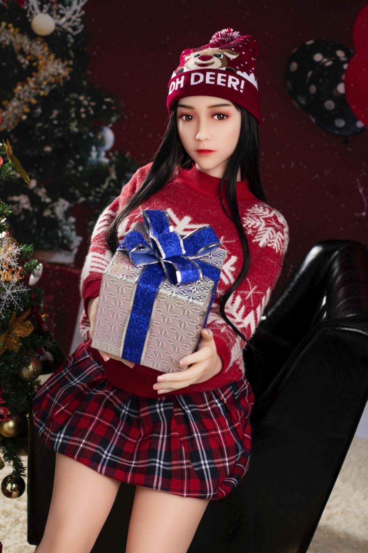 Girl in festive Christmas sweater and hat holding gift box with Christmas tree in background, holiday season celebration, joyful winter festivities, seducedoll image.