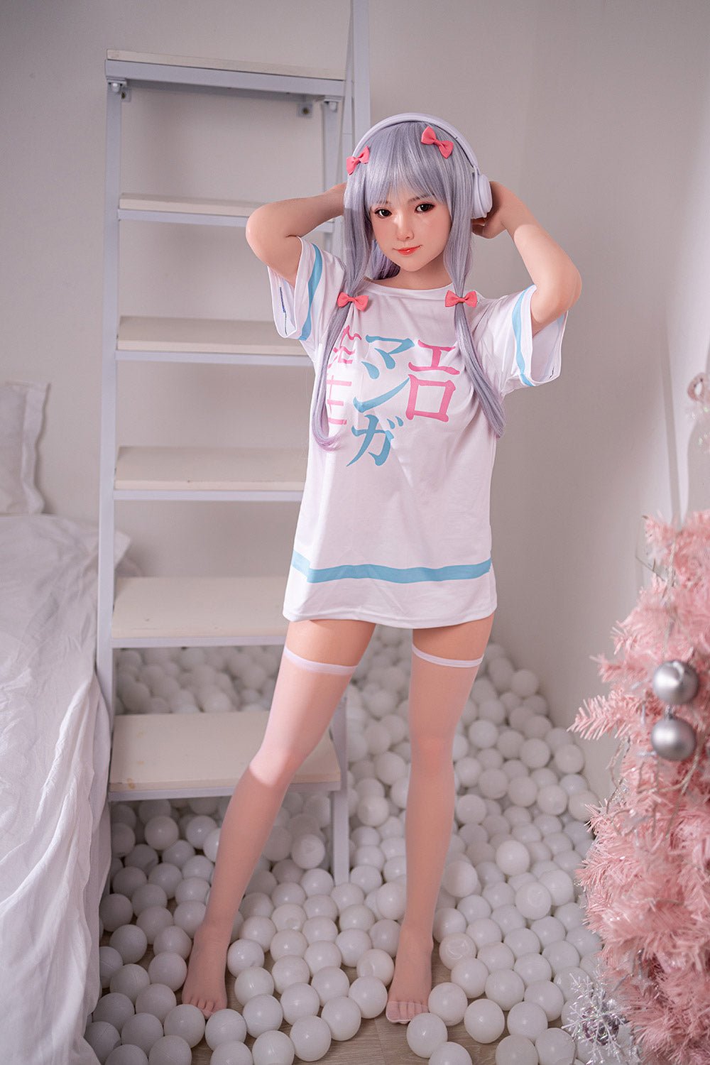 Cute anime-style doll wearing pastel dress with Christmas decor, standing in white ball pit.