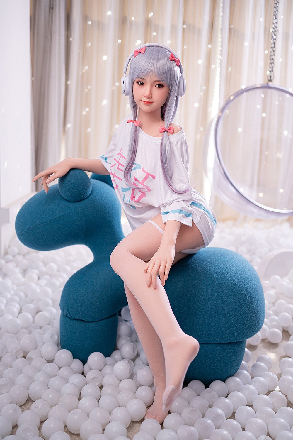 Silicone sex doll with anime-inspired appearance wearing headphones and casual outfit in playful setting.