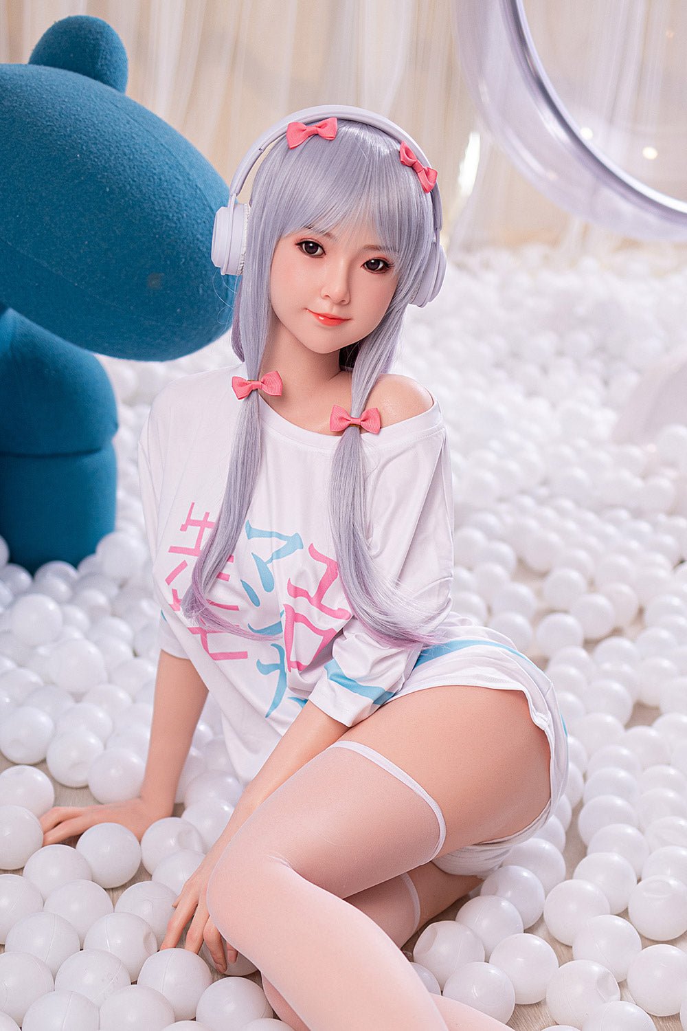 Cute anime sex doll with purple hair and pink bows in a ball pit.