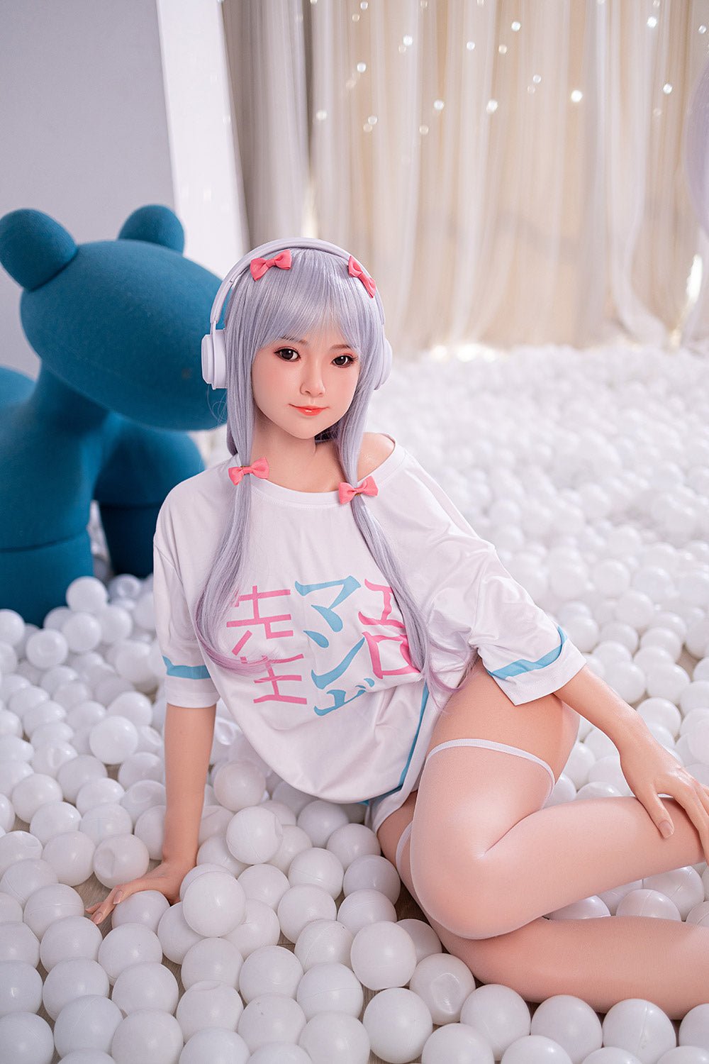Soft silicone doll girl with anime-style features in a playful ball pit scene.