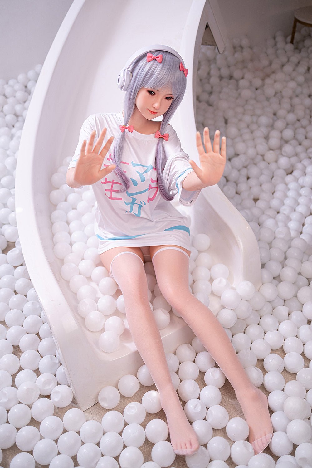 Soft-appeal sex doll with anime-inspired look, sitting in a ball pit, playful pose.